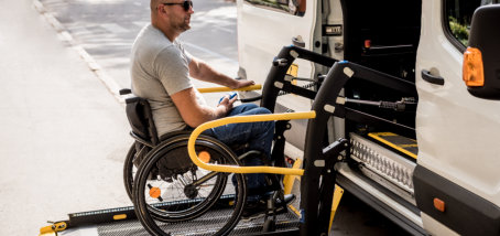 elder in wheelchair beside van
