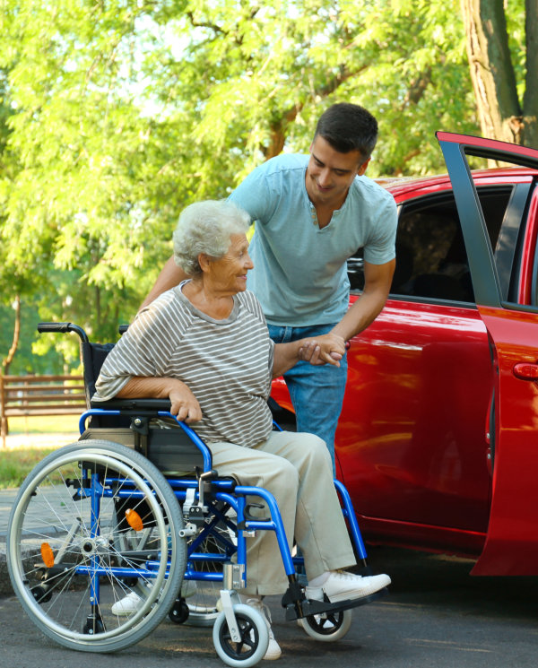 man pushing man in wheelchair into the van