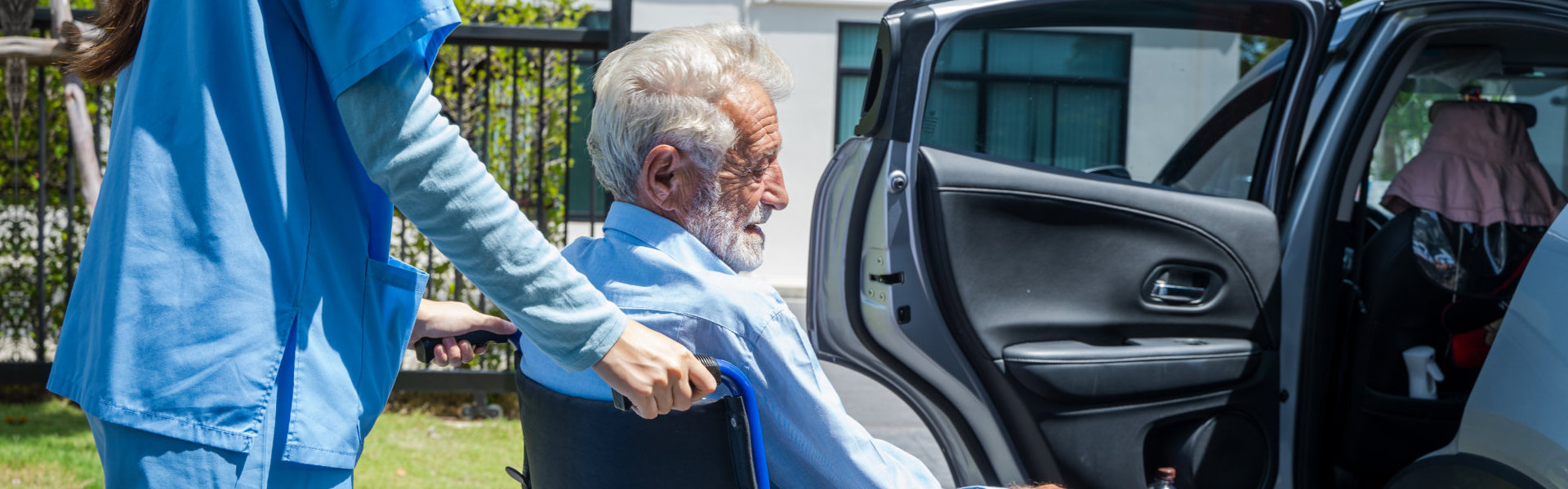 Elderly Man Assisted into Vehicle by Caregiver